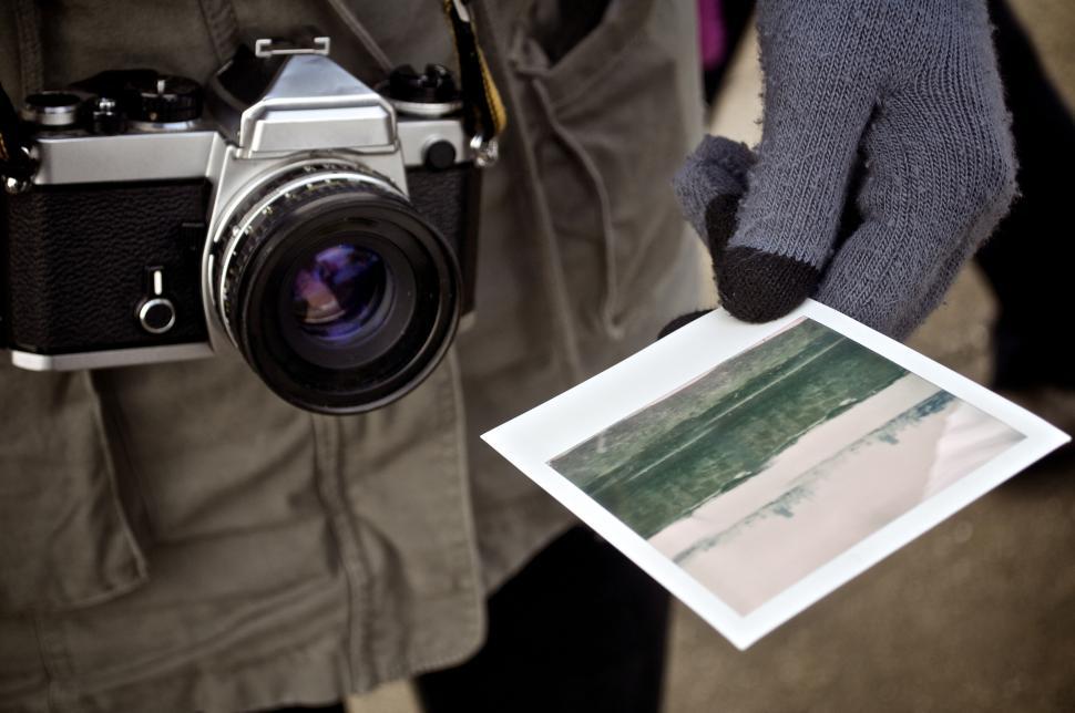 hand-holding-an-instant-photo-near-vintage-camera-outdoors..jpg