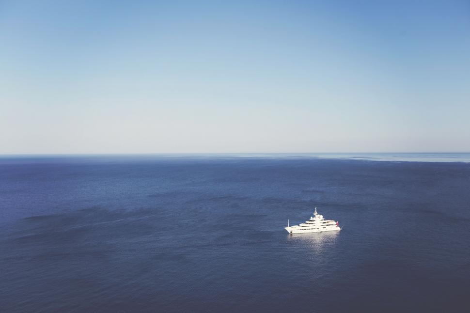 Free Image of White yacht in the vast open ocean with clear sky 