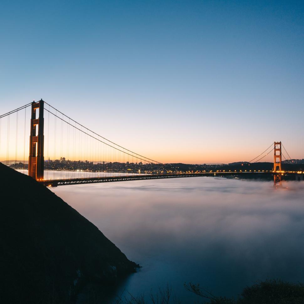 Free Image of Golden sunrise over the bridge with misty waters 