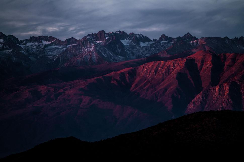Free Image of Sunset over a mountain range with dramatic red hues. 