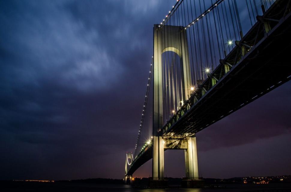 Free Image of Luminous bridge under a dramatic, cloudy night sky. 