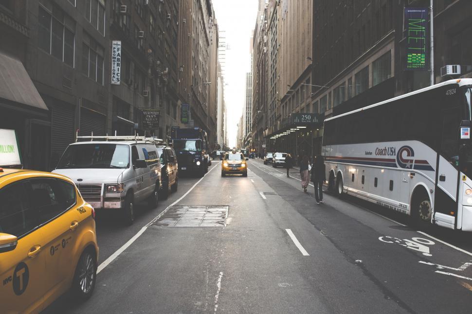 Free Image of Bustling city street with traffic and iconic yellow taxis 
