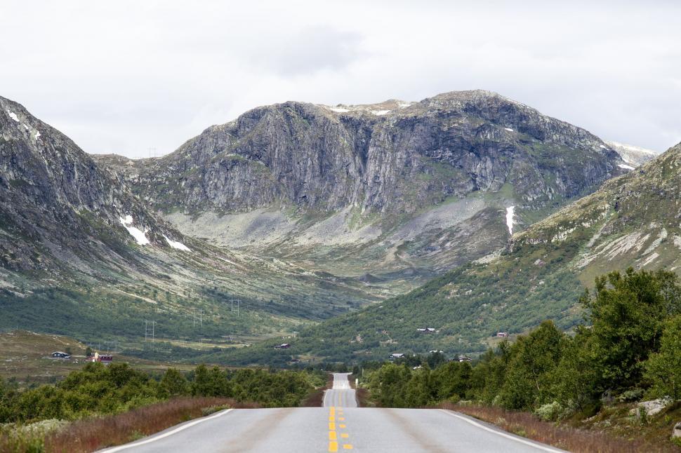 Free Image of Scenic mountain road leading through a green valley view 