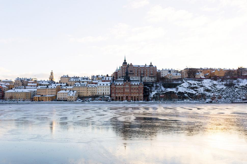 Free Image of Frozen lake view with picturesque buildings nearby 