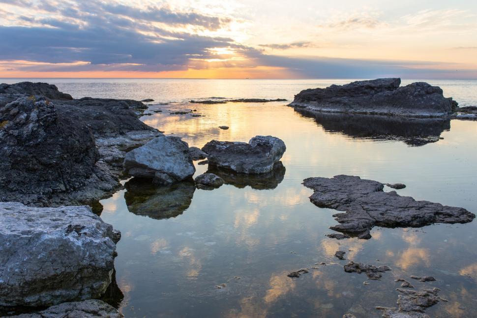 Free Image of A serene coastal sunset, reflecting on calm waters 