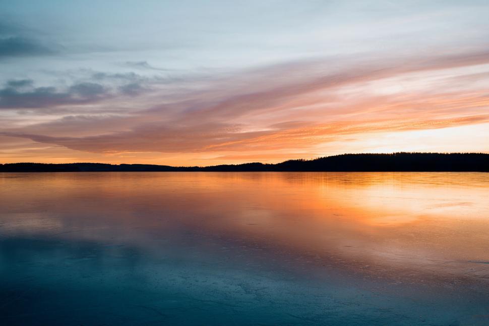 Free Image of Colorful sunset reflecting on calm frozen lake 