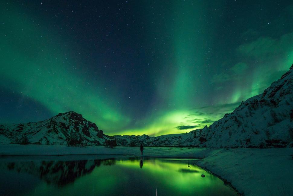 Free Image of Dancing northern lights over snowy landscape at night 