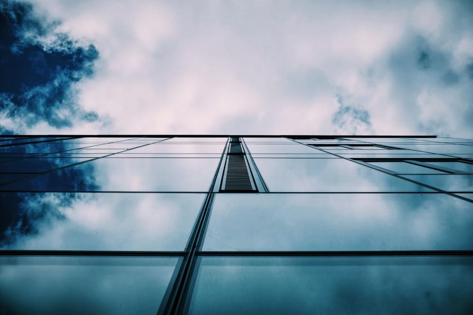 Free Image of Glass building facade reflecting clouds in the sky 