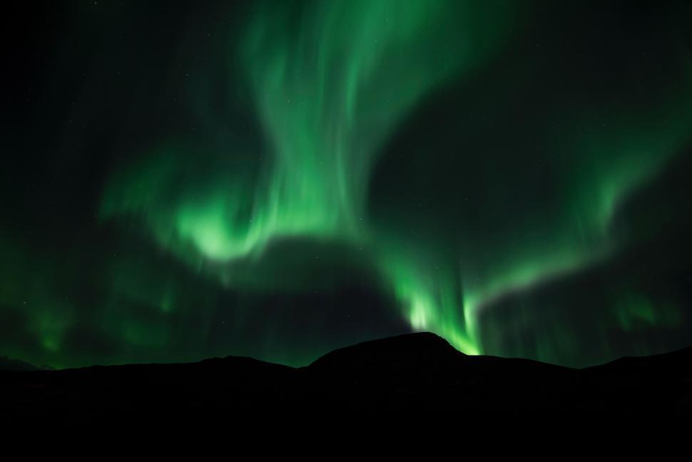 Free Image of Northern lights over dark landscape with green lights 