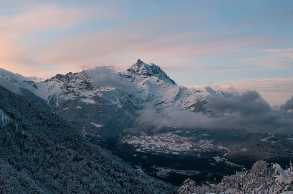Free Image of A majestic snow-covered mountain peak at sunrise time. 