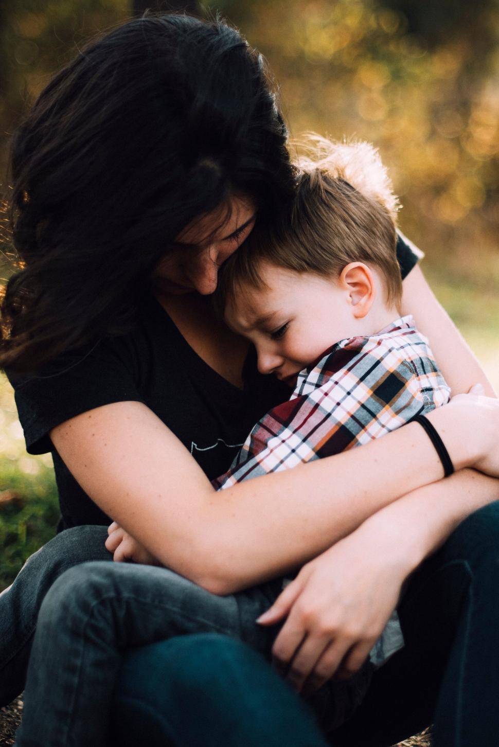 Free Image of Mother embracing young child in outdoor setting 