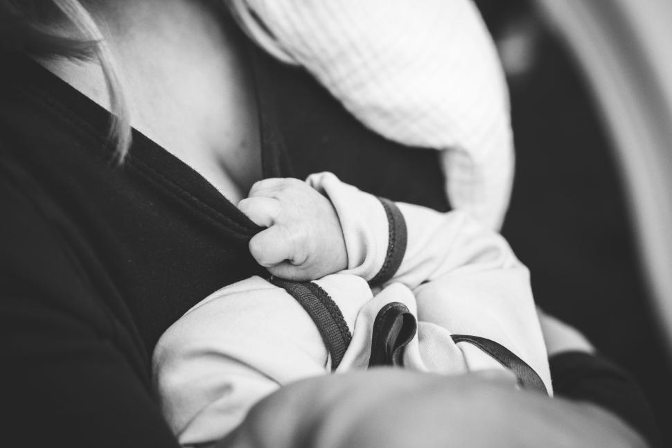 Free Image of Baby holding mother s clothing during breastfeeding time 