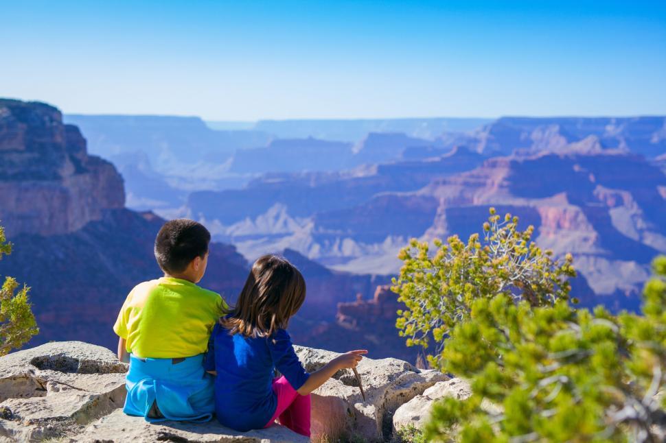 Free Image of Children sitting together enjoying a view of the canyon 