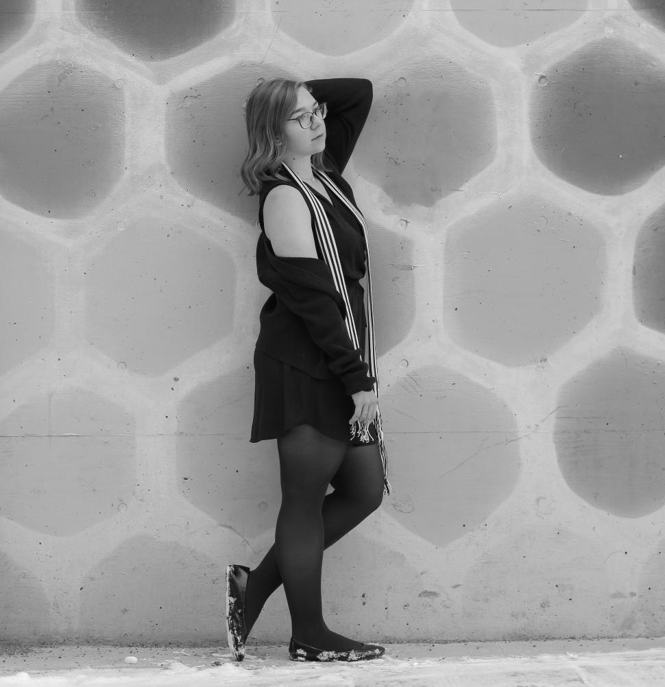 Free Image of Woman standing with a thoughtful pose in black dress. 