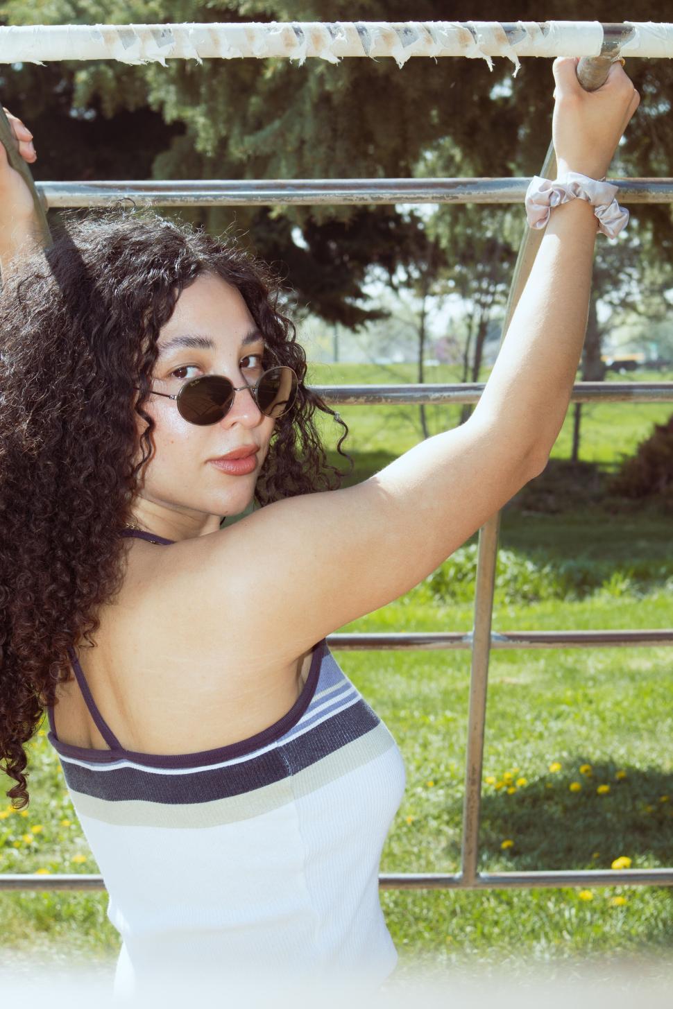 Free Stock Photo of Woman Exercising on Outdoor Pull Up Bar by Lush Trees Download Free Images and Free Illustrations