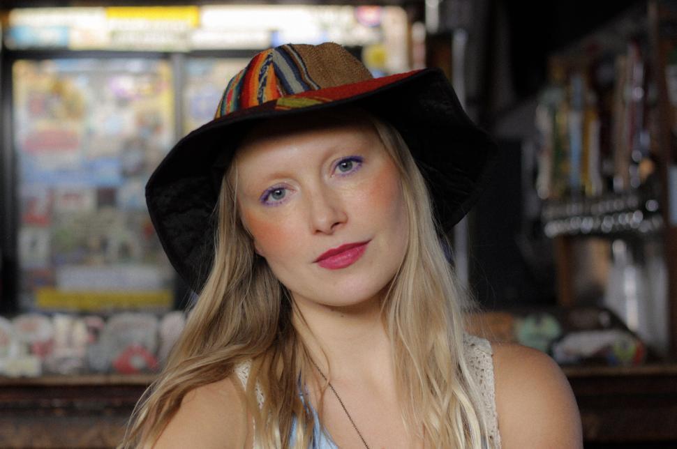 Free Image of Blonde woman with colorful hat in a casual setting 