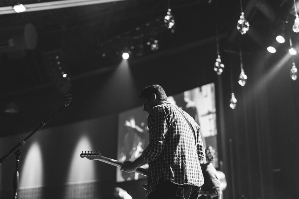 Free Image of Musician playing on stage with guitar during concert 