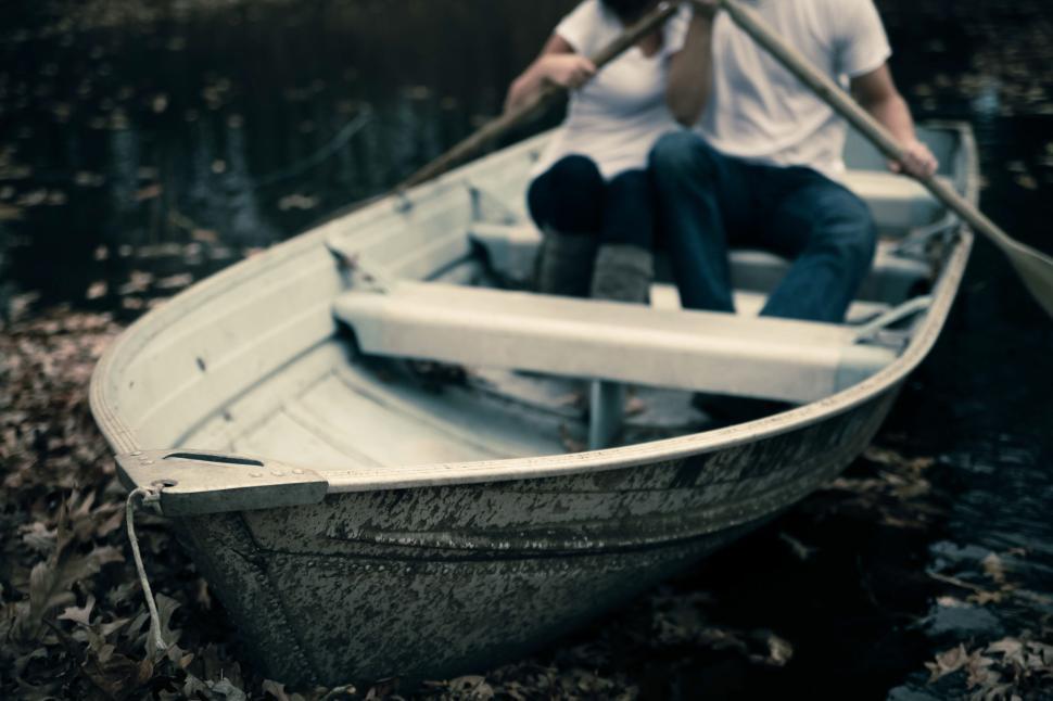 Free Image of Couple rowing boat on tranquil pond surrounded by foliage 