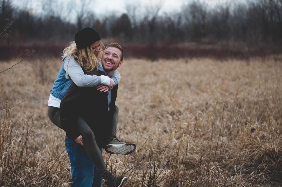 Free Image of Couple enjoying time outdoors in a golden field of grass 