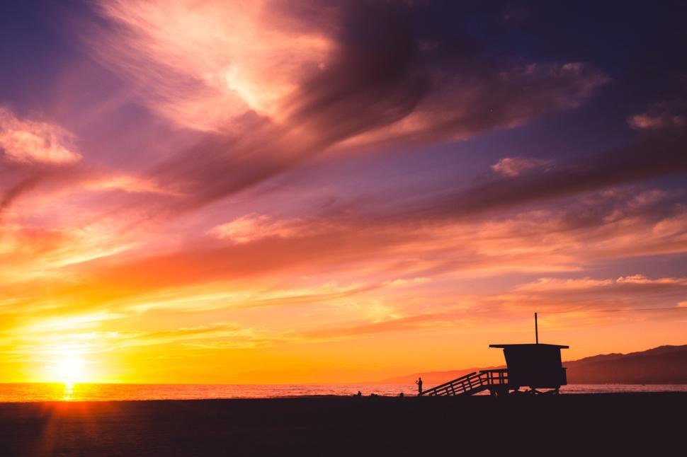 Free Image of Lifeguard tower at beach with vibrant sunset sky 