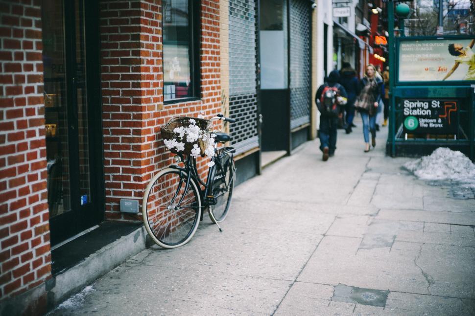 Free Image of Bicycle with flowers parked by Spring Street subway sign. 