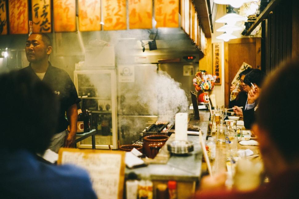 Free Image of Chef in small Japanese restaurant preparing grilled foods 