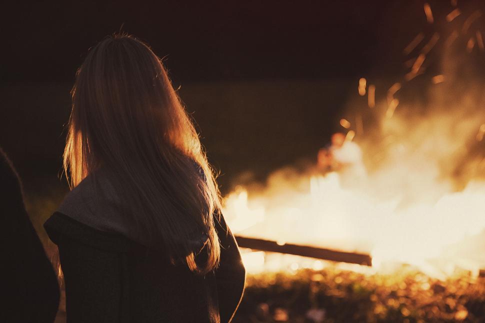 Free Image of Person standing near a fire in the evening darkness. 