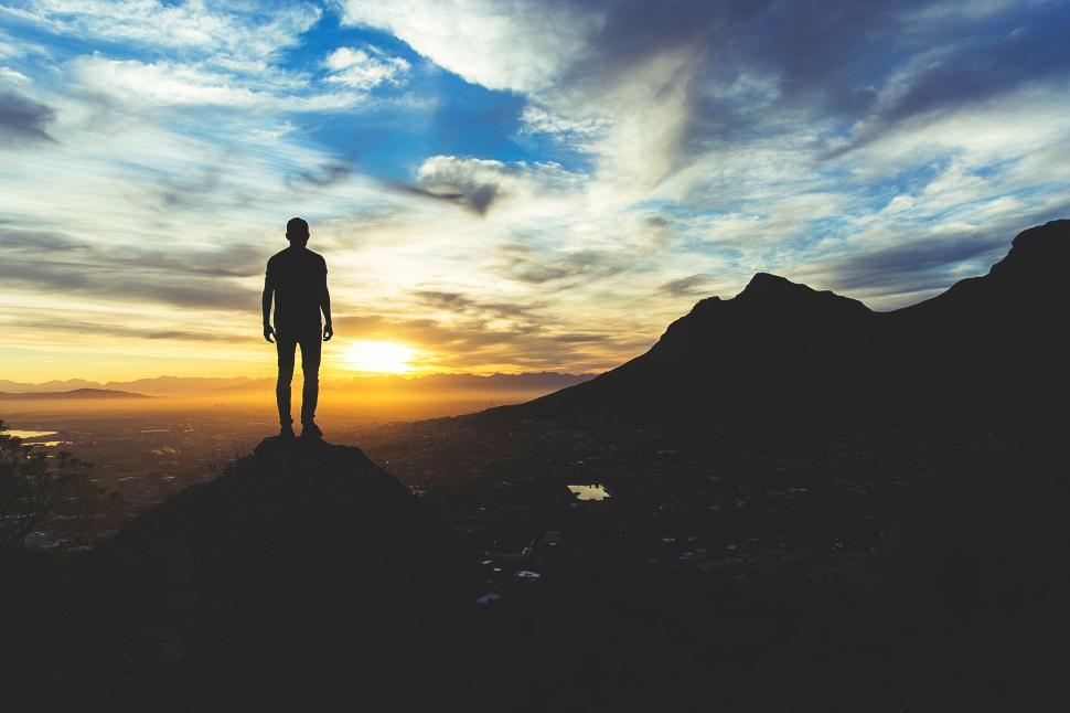 https://freerangestock.com/sample/175781/silhouetted-man-stands-on-peak-watching-golden-sunrise.jpg