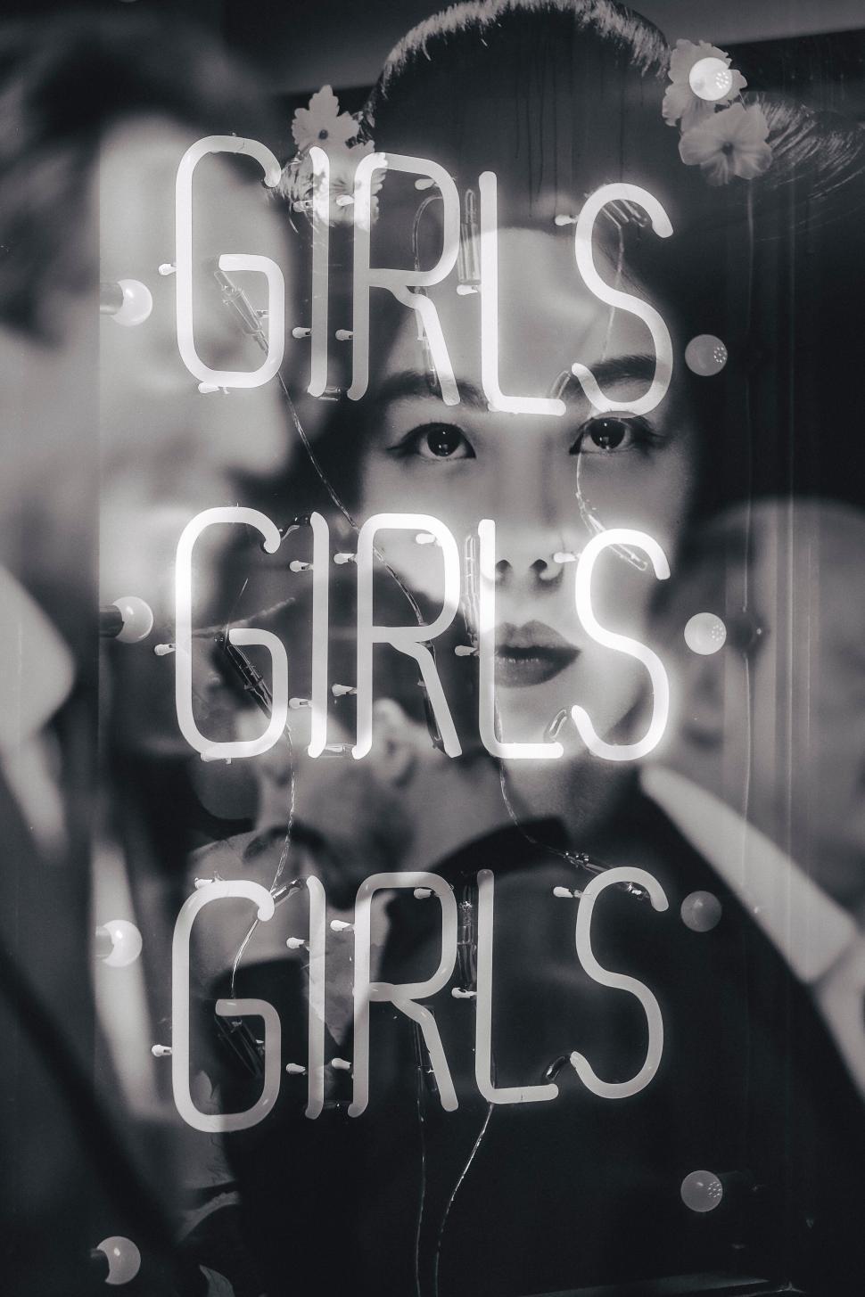 Free Image of Neon sign with repeated word  GIRLS  in a nightlife setting. 