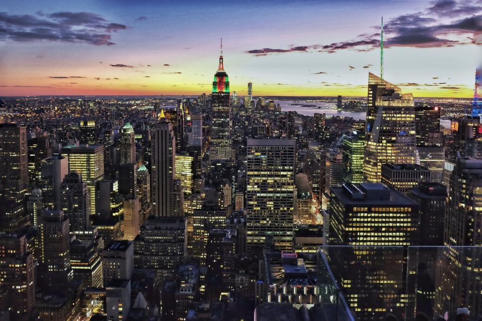 Free Image of New York City skyline at sunset with iconic skyscrapers illuminated. 