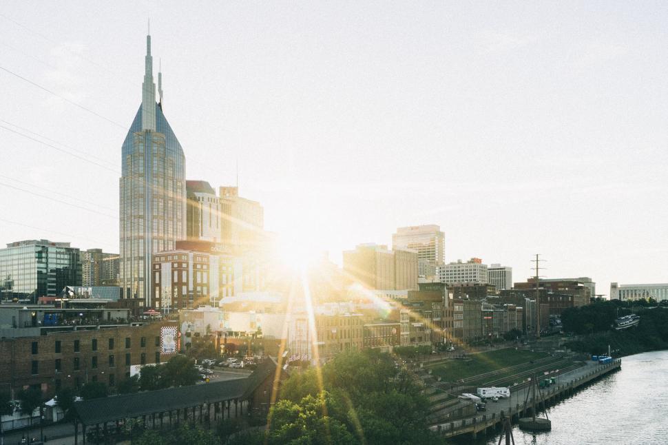 Free Image of Cityscape with tall building and sun setting in the background. 