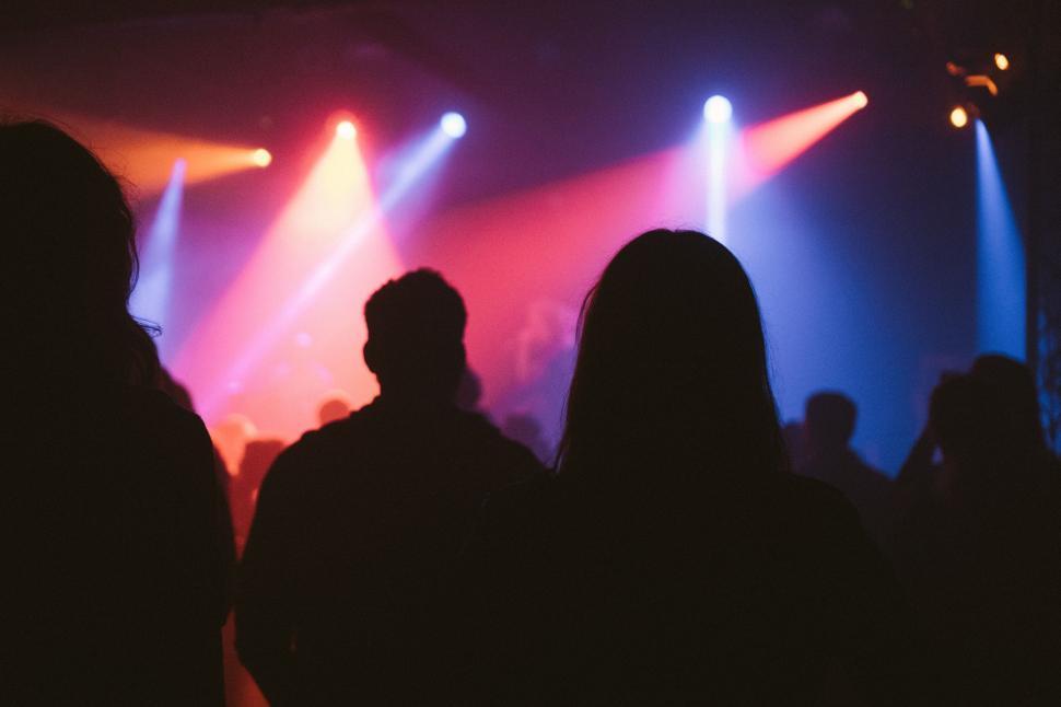 Free Image of Vibrant nightclub dance floor with colorful lights and silhouettes. 