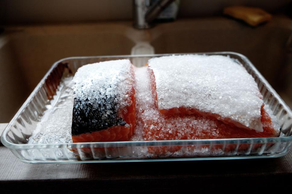 Free Image of Glass dish with salted salmon pieces on a kitchen countertop. 