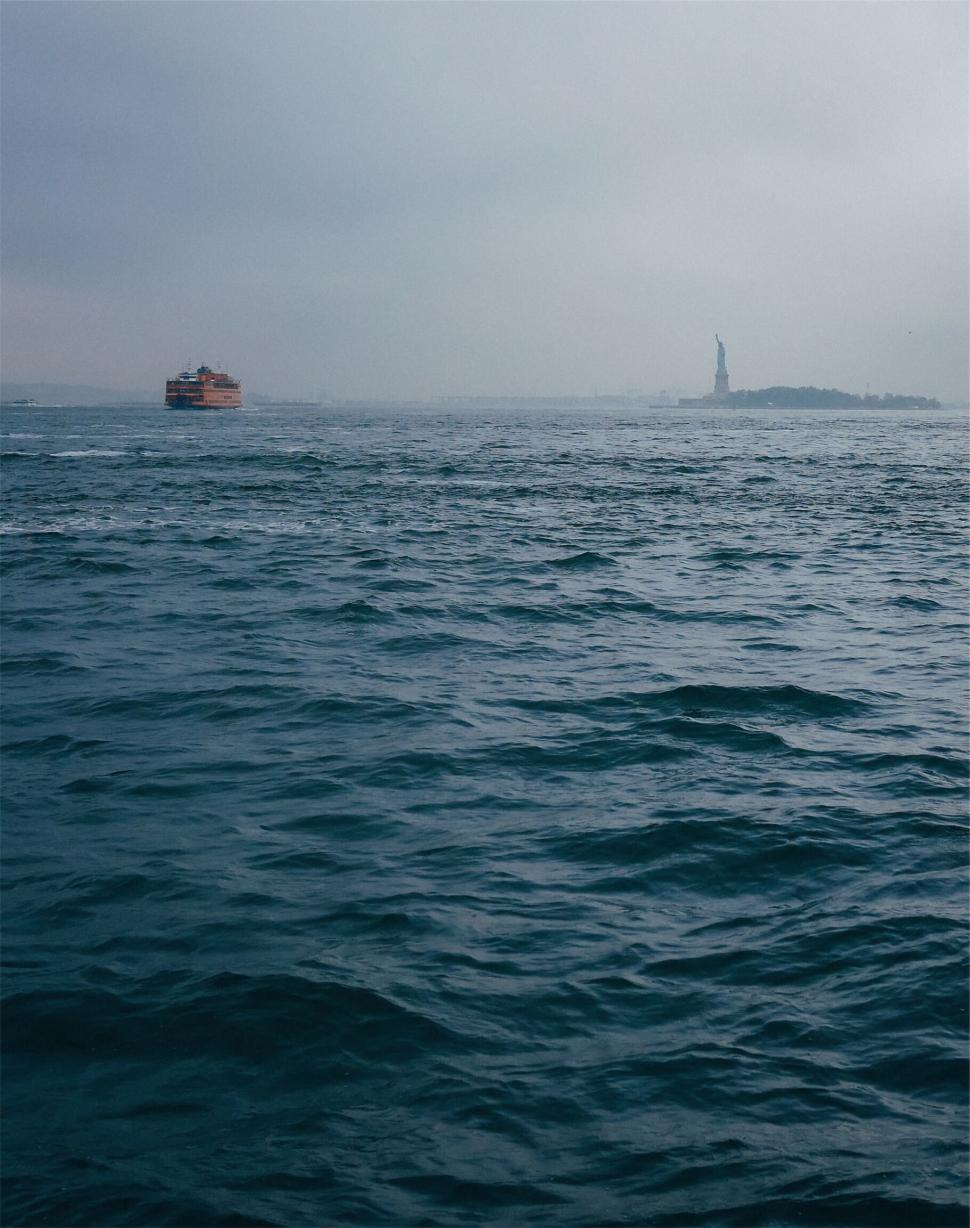 Free Image of Statue of Liberty as seen from the distance in cloudy weather 
