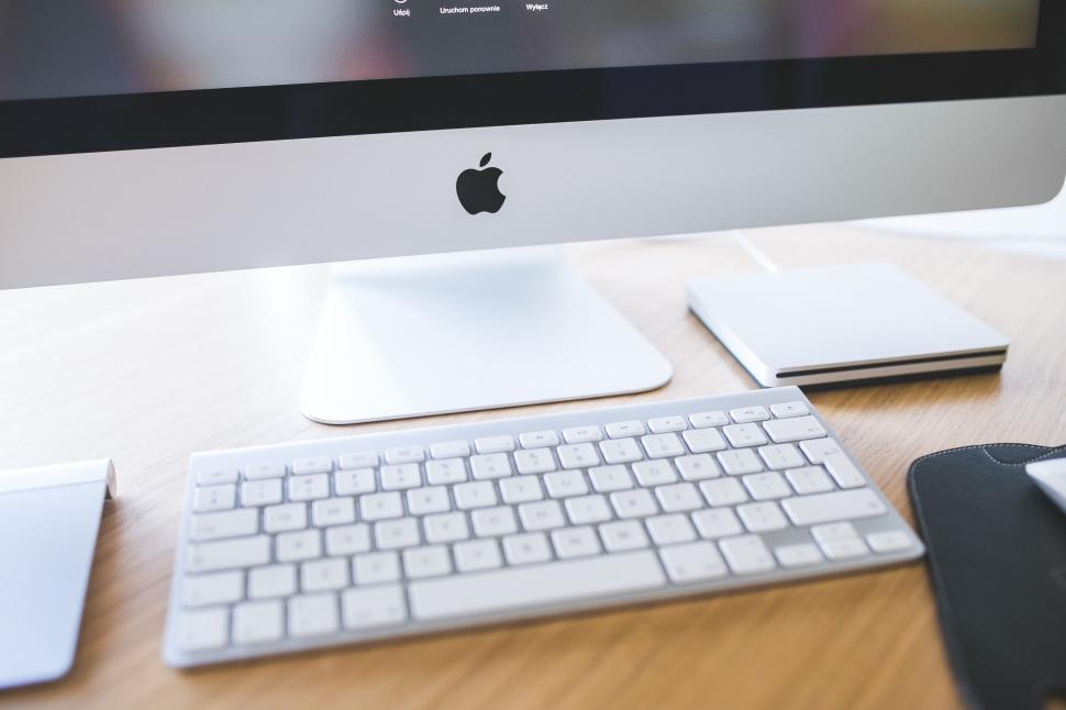 Free Image of Apple desktop computer with keyboard and mouse on a wooden desk 