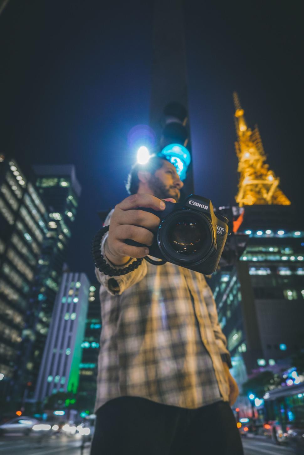 Free Image of Person with Camera at Night in Cityscape with Bright Lights 
