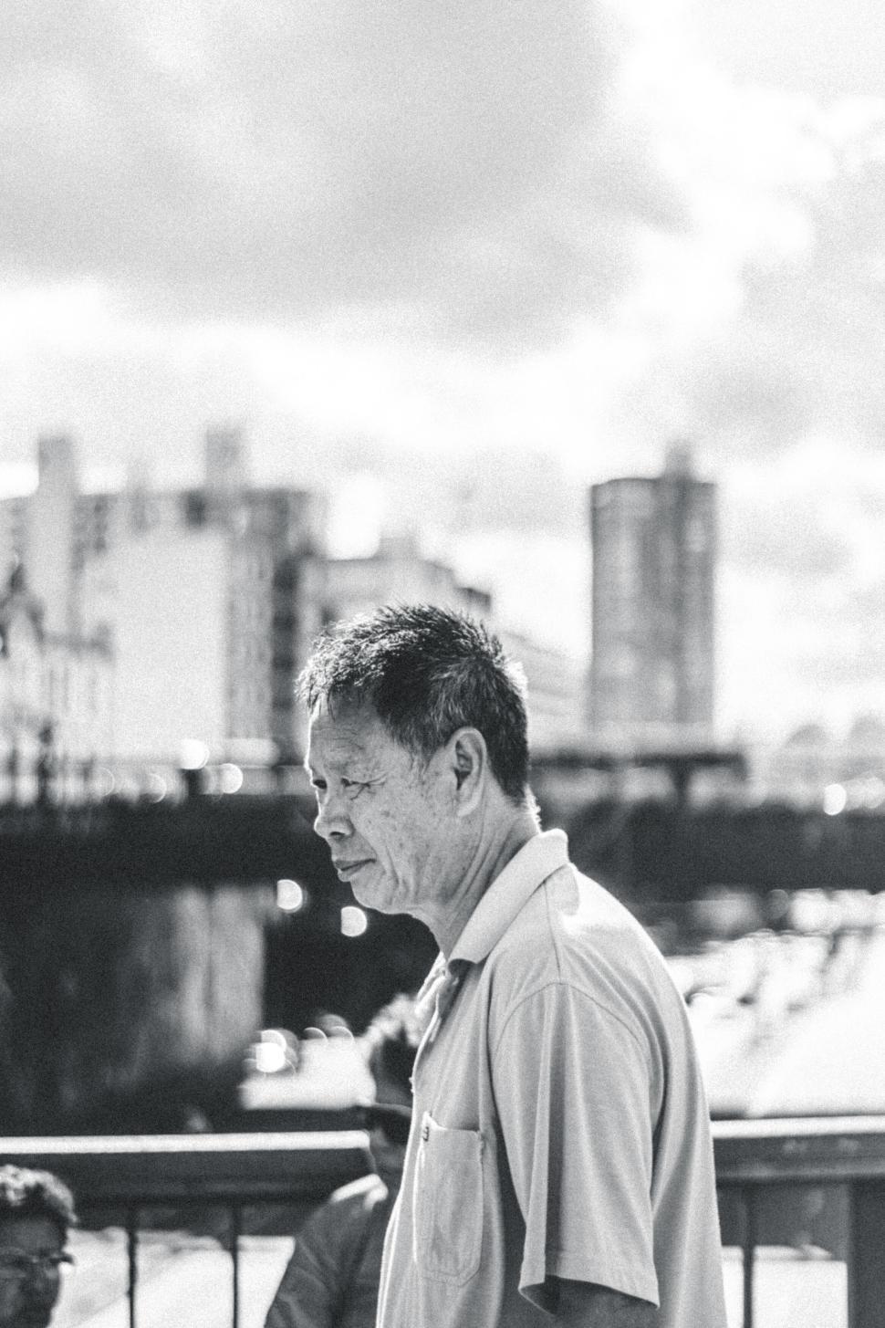 Free Image of Elderly man walking on the street in a black and white capture 