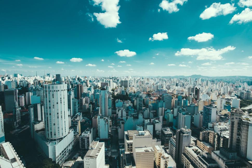 Free Image of Aerial view of an expansive cityscape under a bright blue sky. 