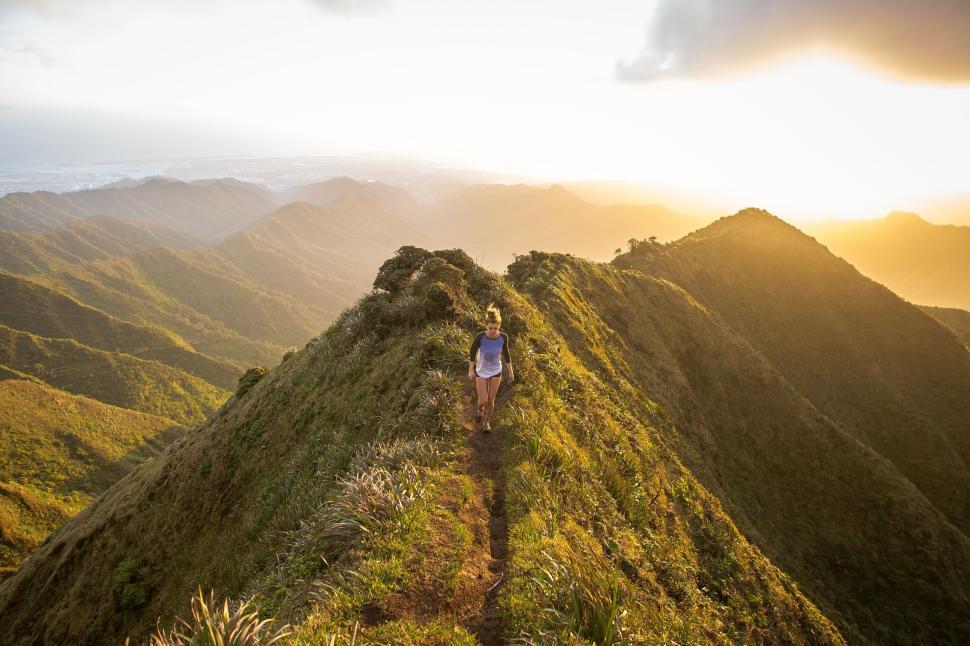 Free Image of Person hiking along a scenic mountain ridge at sunset 