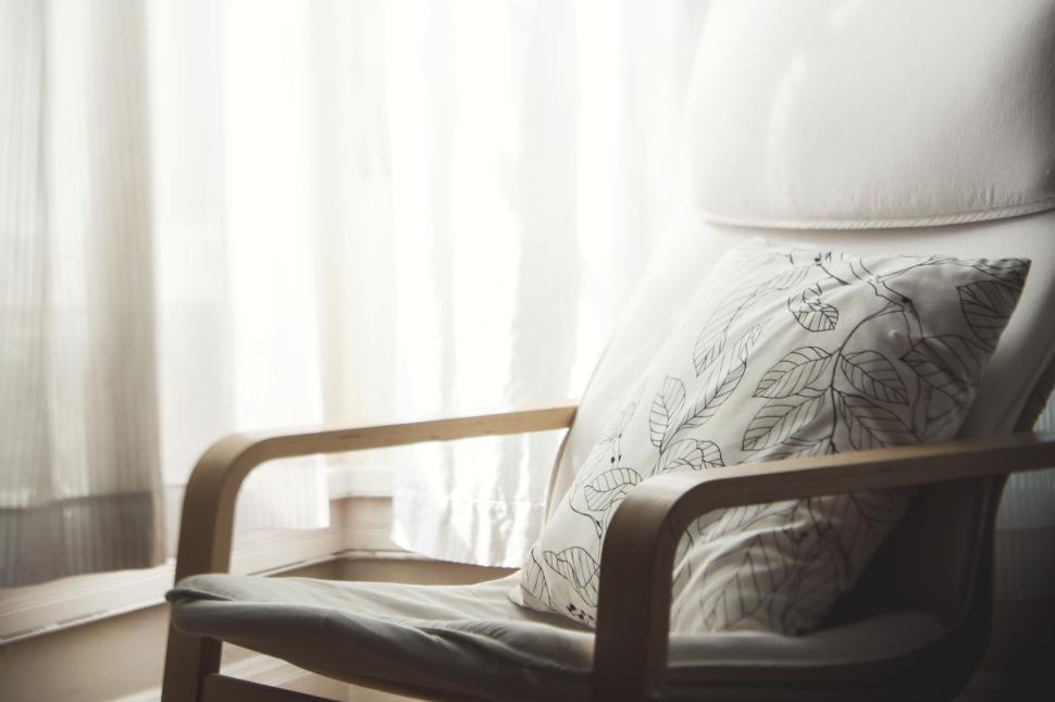 comfortable-chair-with-a-decorative-pillow-in-sunlit-living-room.jpg