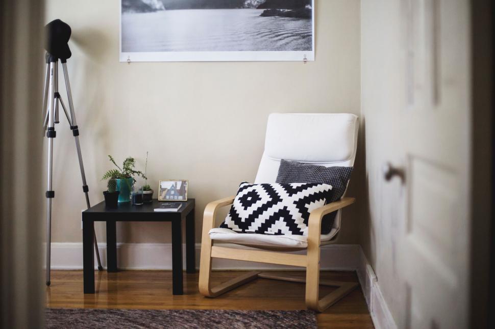 Free Image of Cozy reading nook with a chair, pillows, and a telescope 