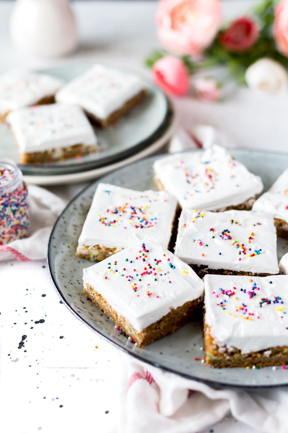 Free Image of Square shaped vanilla frosted bars topped with colorful sprinkles 