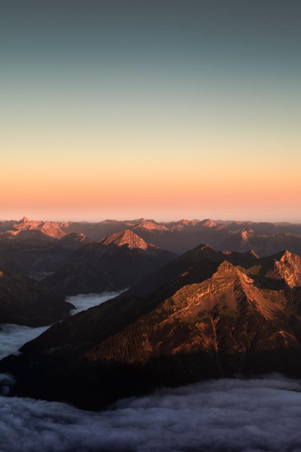Free Image of Mountain peaks catching golden light of the setting sun. 