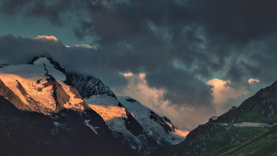 Free Image of Snow-capped mountains under dramatic sky with dark clouds. 