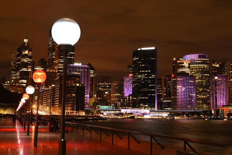 Free Image of Night cityscape featuring illuminated skyscrapers and waterfront. 