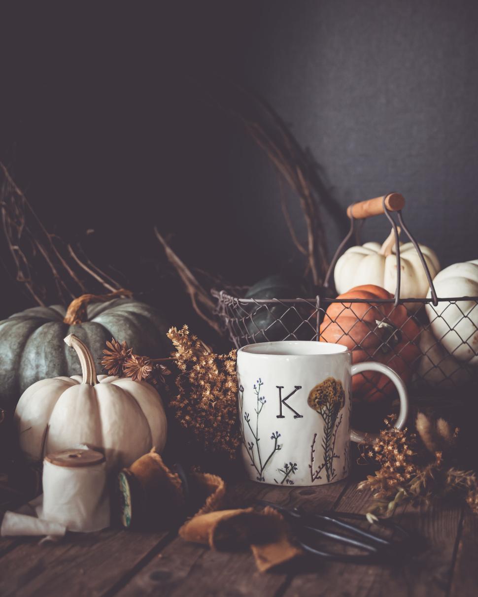 Free Image of Cozy autumn scene with a monogrammed mug and pumpkins on a table 