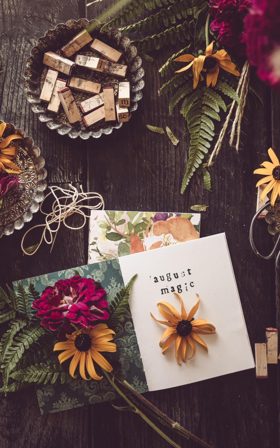 Free Image of Assortment of flowers and stationery arranged for artistic flat lay photo. 
