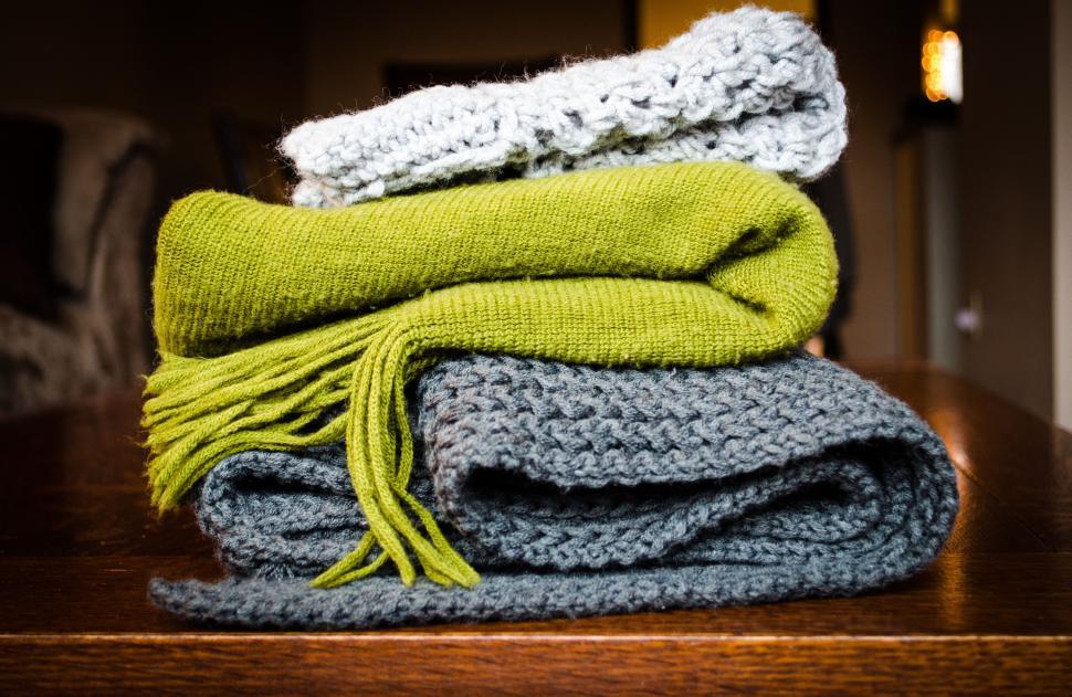Free Image of Stack of cozy folded blankets in varying textures and colors. 
