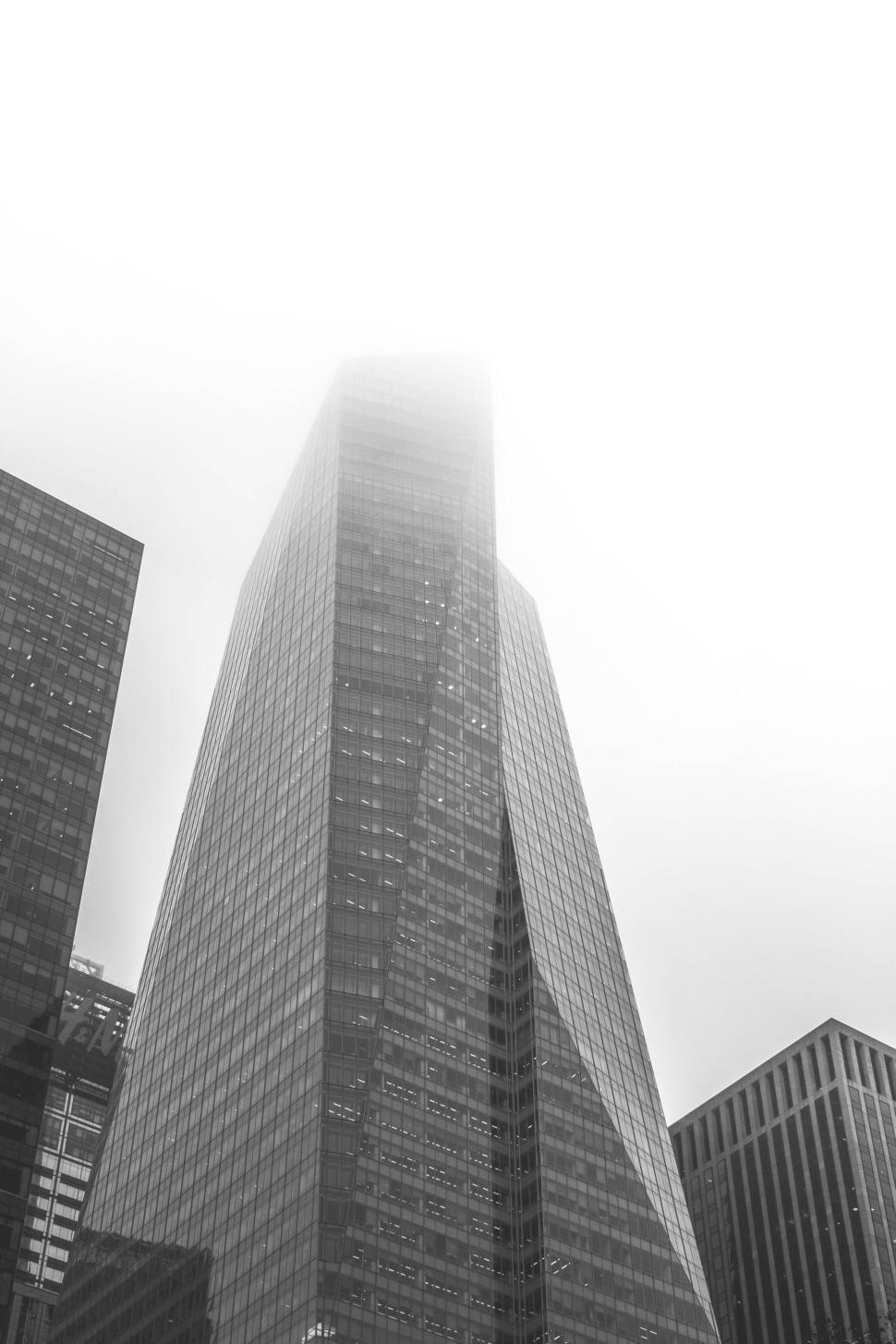 Free Image of Tall skyscraper disappearing into the misty sky urban landscape 