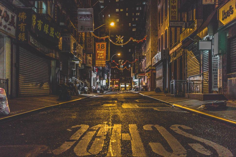 Free Image of Empty city street at night adorned with festive decorations and lights 